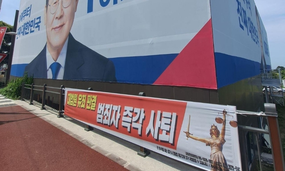 이재명 비방 현수막 '문제없다'? … 민주당 제주 선거사무소 앞 현수막 논란
