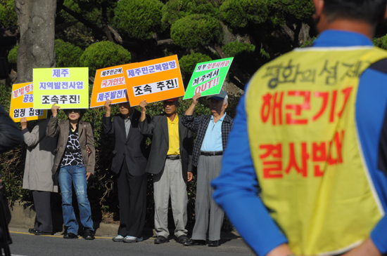 해군기지 반대측이 지켜보는 가운데 해군기지 찬성측이 집회를 갖고 있다.