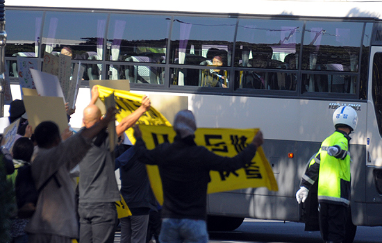 제주해군기지 반대측이 국회의원들이 탑승한 차량을 향해 깃발과 피켓을 흔들고 있다.