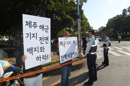 제주해군기지 반대측이 신제주로터리에서 피켓을 들고 서 있다.